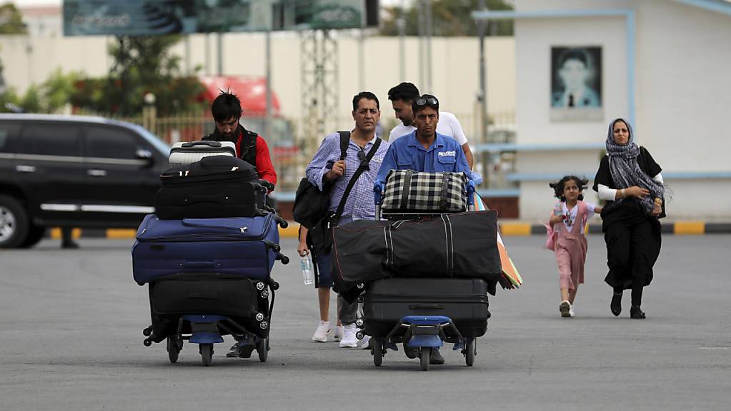 Passagiere gehen zum Abflugterminal des internationalen Flughafens Hamid Karzai in Kabul, Afghanistan. Da die afghanische Hauptstadt von einer Taliban-Offensive umzingelt ist, gibt es für diejenigen, die vor dem Krieg fliehen, zunehmend nur noch einen Weg nach draußen.