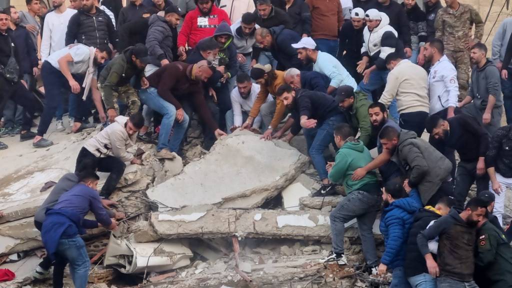 dpatopbilder - Rettungskräfte und Anwohner suchen nach Überlebenden in den Trümmern eines eingestürzten Gebäudes. Foto: Uncredited/AP/dpa
