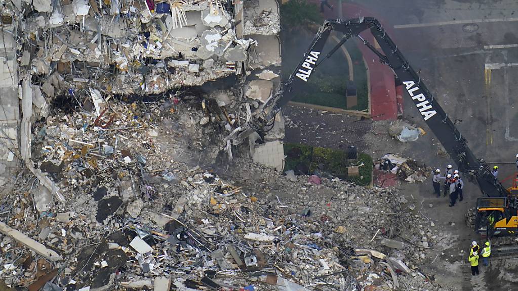 Such- und Rettungskräfte suchen nach Überlebenden in den Trümmern im dem teilweise eingestürzten zwölfstöckigen Gebäude. Foto: Gerald Herbert/AP/dpa