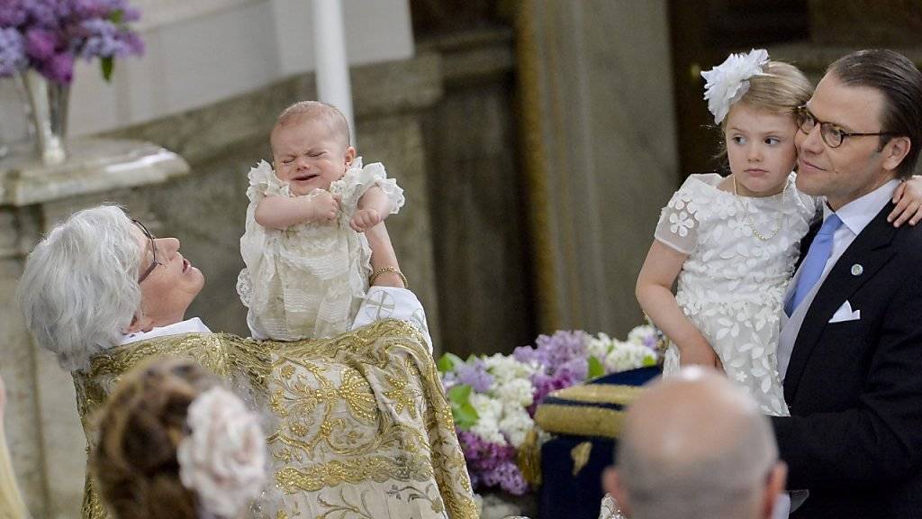 Prinz Oscar bei der Taufe, beobachtet von seiner Schwester Estelle und Vater Prinz Daniel