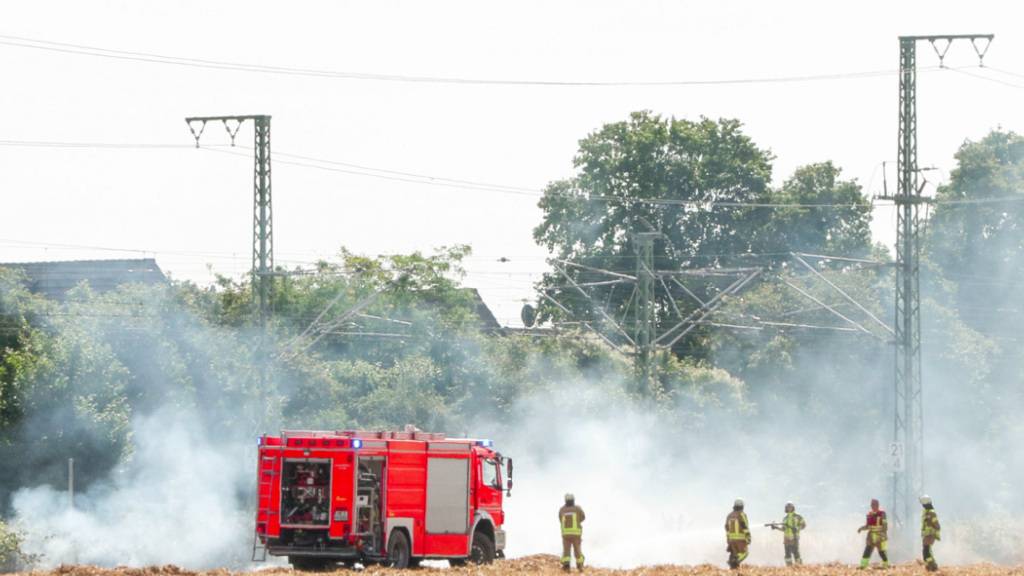 dpatopbilder - Feuerwehrleute bei Löscharbeiten an einer Bahnstrecke. Foto: Patrick Schüller/dpa