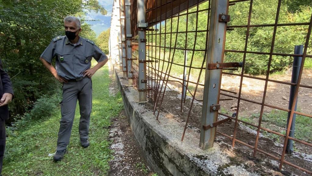 Zwei Männer stehen im Tierpflegezentrum am beschädigten Zaun zum Wildtiergehege. Innerhalb eines Jahres war der Braunbär «M49» - der Ausbrecherkönig unter den norditalienischen Bären – zum zweiten Mal aus einem Wildtiergehege in der Provinz Trentino ausgerissen.
