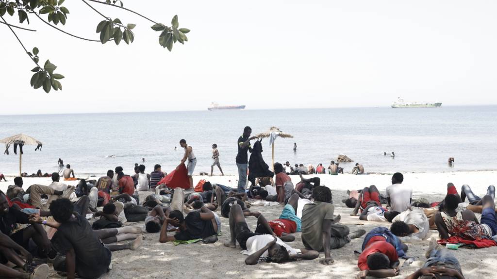Mehrere Migranten erholen sich am Strand. Migranten, denen es in den letzten Tagen gelungen ist, nach Ceuta zu schwimmen, kehren aus eigenem Antrieb auf die marokkanische Seite in die Stadt Castillejos zurück. Nach Angaben der spanischen Regierung sind mittlerweile fast alle Migranten nach Marokko zurückgekehrt. Foto: Jesús Torres/EUROPA PRESS/dpa