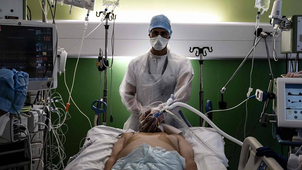 Ein medizinischer Angestellter kümmert sich in der Intensivstation des Krankenhauses Lyon-Süd in Pierre-Benite um einen Corona-Patienten.