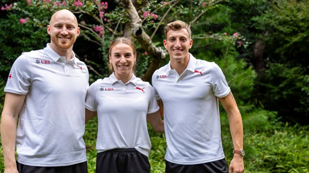Simon Ehammer (rechts) lässt sich den Empfang des Schweizer Team in der Schweizer Botschaft in Japan nicht entgehen: Er posiert für das Foto zusammen mit Simon Wieland, Rekordhalter mit dem Speer, und Annik Kälin, die verletzt für den Siebenkampf passen muss