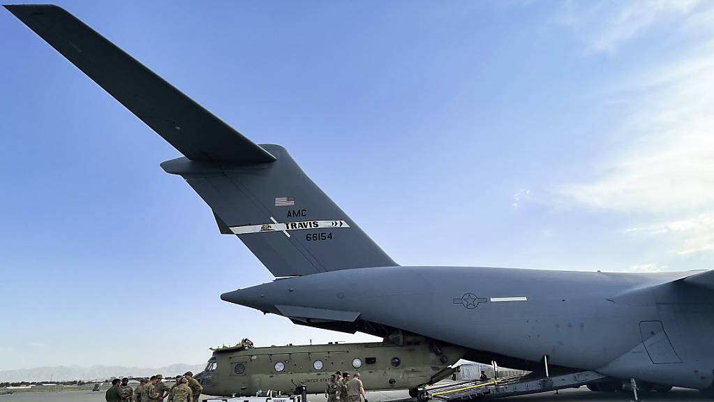 Ein Transporthubschrauber des US-Militärs wird auf dem Kabuler Flughafen in ein Militärtransportflugzeug verladen.