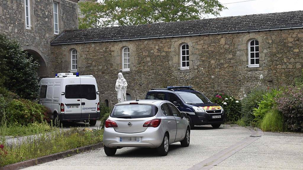 Fahrzeuge der Gendarmerie parken am Ort, an dem in ein 60-jähriger katholischer Priester ermordet wurde. In der Nähe der westfranzösischen Stadt Nantes ist Berichten des Senders Franceinfo zufolge ein katholischer Priester in der kleinen Gemeinde Saint-Laurent-sur-Sèvre getötet aufgefunden worden. Foto: Sebastien Salom-Gomis/AFP/dpa