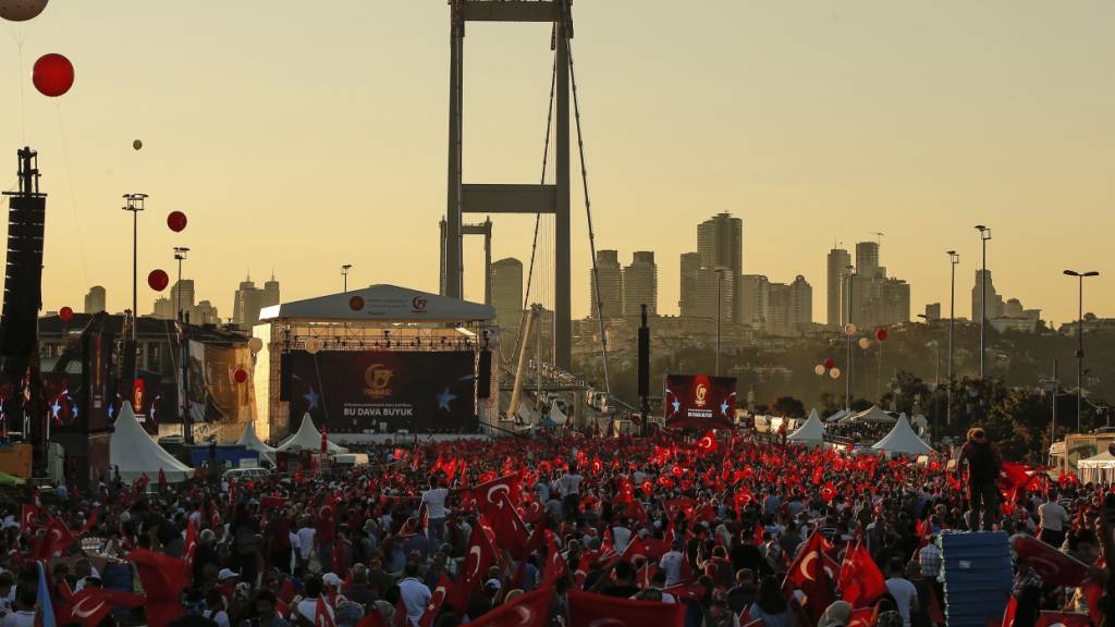 ARCHIV - 15.07.2018, Türkei, Ankara: Menschen schwenken türkische Flaggen bei einer Gedenkveranstaltung zum zweiten Jahrestag des Putschversuchs auf der Brücke der Märtyrer des 15. Juli, ehemals Erste Brücke, auf der in der Putschnacht zahlreiche Zivilisten starben. Foto: Emrah Gurel/AP/dpa