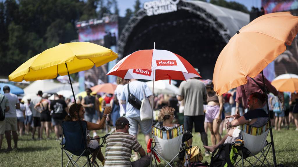 In St. Gallen werden drei Tage nacheinander Temperaturen über 30 Grad gemessen - Rekord egalisiert. Im Bild: Besucher mit Sonnenschirm vor der Hauptbühne am Openair St. Gallen 2026.