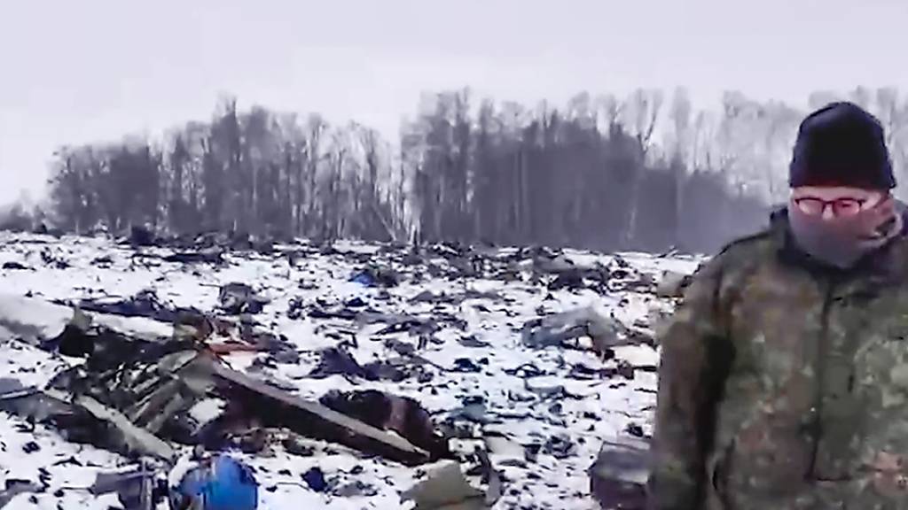 HANDOUT - Ein Mitarbeiter des Russischen Ermittlungskomitees geht in der Nähe von Jablonowo in der Region Belgorod durch ein Gebiet, in dem Wrackteile der russischen Militärmaschine Il-76 abgestürzt sind. Die Ukraine hält die von Russland zum mutmaßlichen Abschuss der militärischen Transportmaschine Il-76 bisher vorgelegten Angaben für nicht stichhaltig. Foto: Uncredited/Russian Investigative Committee/AP/dpa