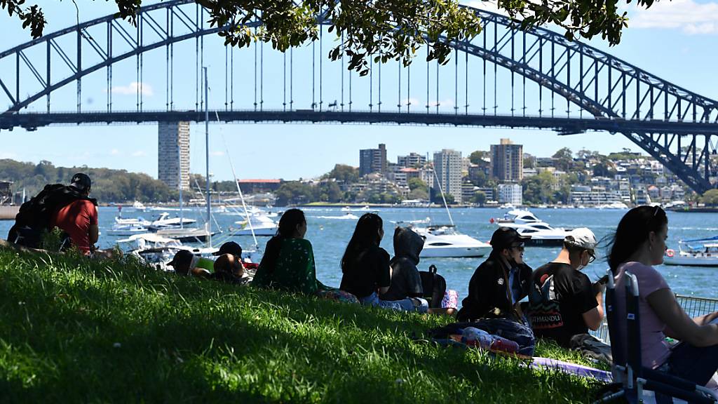 Small crowd numbers are seen gathered at Mrs Macquaries Chair ahead of New Years Eve celebrations in Sydney, Friday, December 31, 2021. Fireworks at 9pm and midnight will be displayed against the backdrop of the Sydney Opera House and Sydney Harbour Bridge with crowd numbers expected to be low due to increasing COVID 19 case numbers with more than 21,000 infections recorded in the past 24 hours. (AAP Image/Dean Lewins) NO ARCHIVING