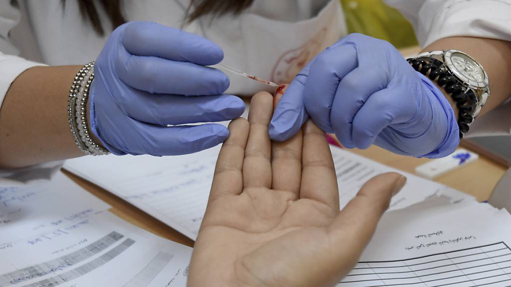 Eine Mitarbeiterin des tunesischen Gesundheitsministeriums nimmt in einer Schule eine Blutprobe, um einen Schüler auf eine Covid-19-Infektion zu testen. Rund drei Monate nach Ausbruch des Coronavirus hat Tunesien die Pandemie nach eigener Aussage besiegt. Foto: Hassene Dridi/AP/dpa