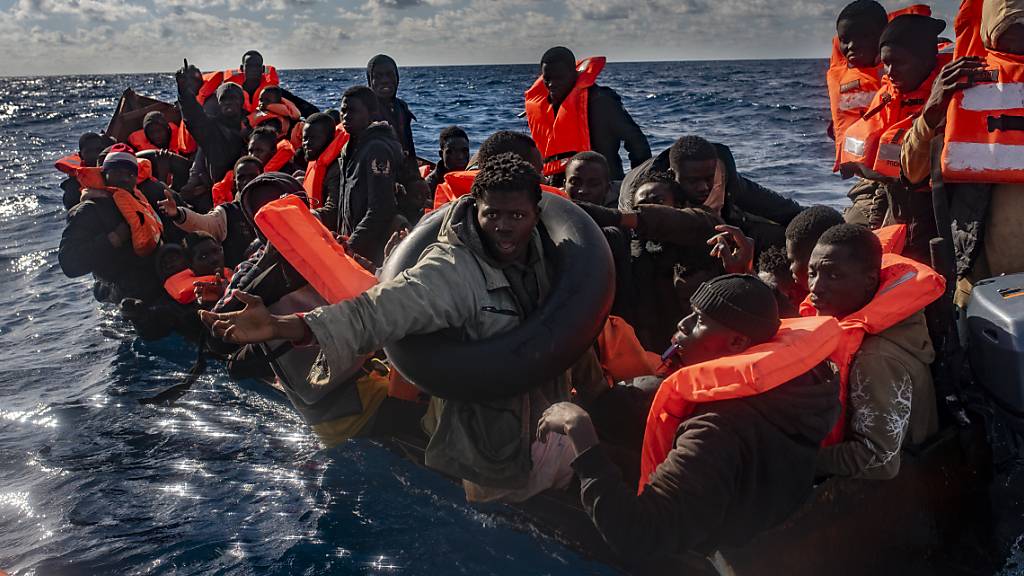 ARCHIV - Mehrere Migranten in einem Boot im Mittelmeer, während Rettungskräfte versuchen ihnen zu helfen. Foto: Antonio Sempere/EUROPA PRESS/dpa