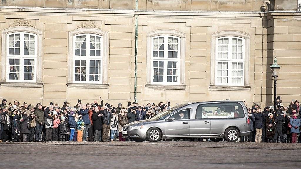 Zahlreiche Däninnen und Dänen säumen die Strassen: Das Fahrzeug mit dem Sarg Henriks kommt am Amalienborg Palast in Kopenhagen an.