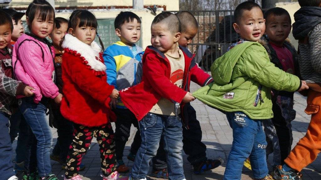Chinesische Kinder auf dem Schulweg - verheirateten Paaren ist es künftig erlaubt, ein zweites Kind zu bekommen. (Symbolbild)