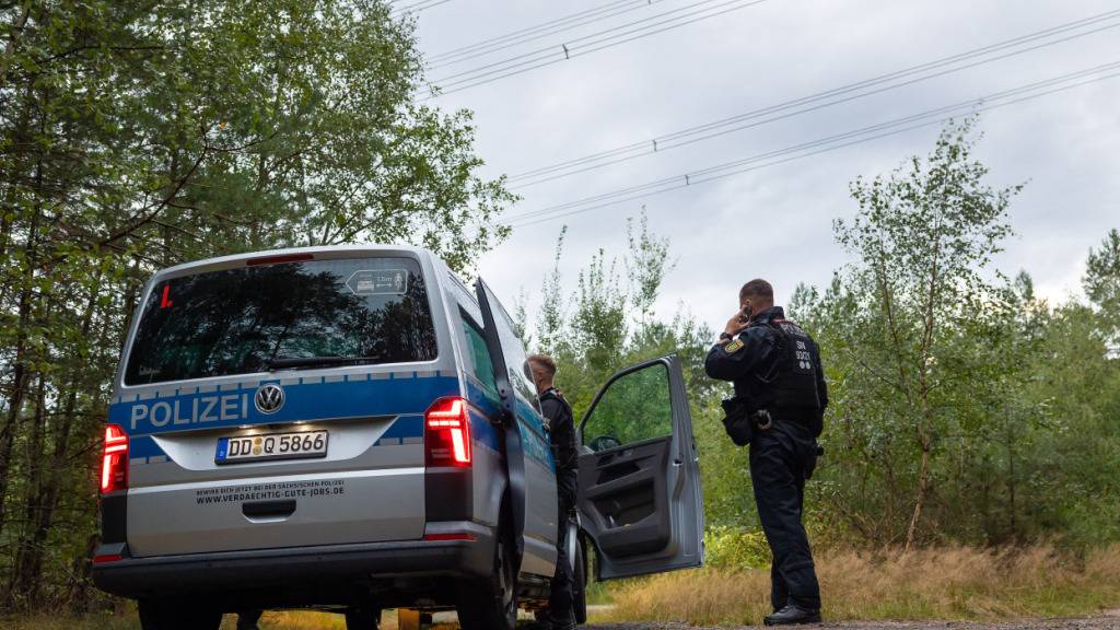 dpatopbilder - Polizeikräfte stehen in einem Waldstück unter einer Stromtrasse nahe dem Ort Schleife im Landkreis Görlitz. Nach Sabotageversuchen gegen die Stromversorgung in anderen Bundesländern hat die Polizei nun auch in Sachsen «unbekannte Sprengvorrichtungen» entdeckt. Foto: Jürgen Lösel/dpa