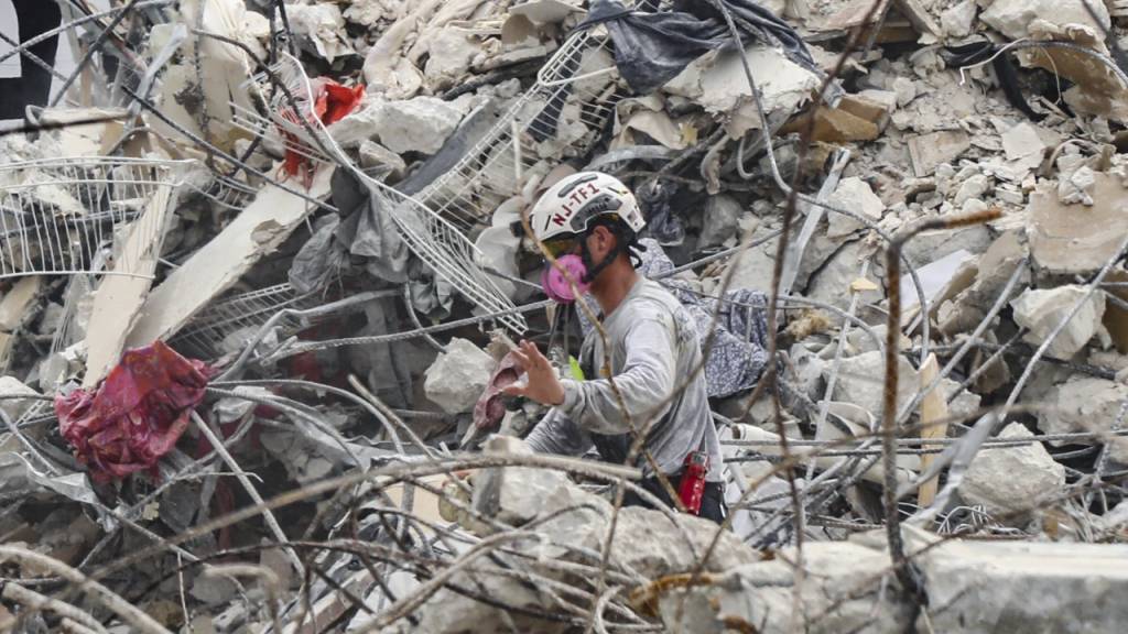 Rettungskräfte arbeiten sich durch die Trümmern des teilweise eingestürzten Wohnkomplexes. Foto: Al Diaz/Miami Herald/AP/dpa