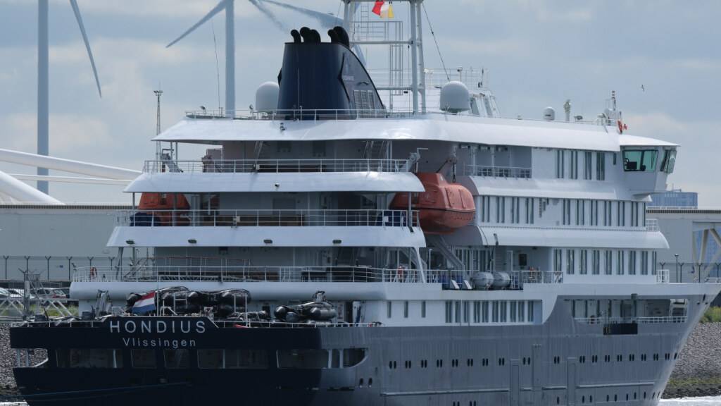 Das Kreuzfahrtschiff «Hondius» läuft in den Hafen von Rotterdam ein. An Bord des von einem Hantavirus-Ausbruch betroffenen Schiffes befinden sich laut Angaben der niederländischen Reederei Oceanwide Expeditions noch Besatzungsmitglieder. Foto: Patrick Post/AP/dpa