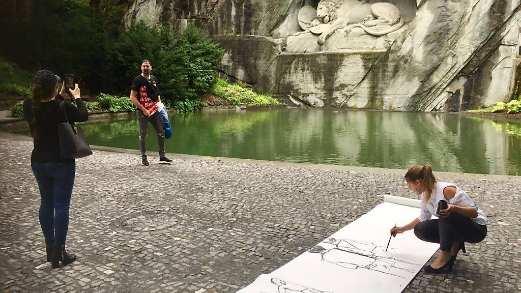 Die Künstlerin Olga Georgieva kreiert ein Live-Bild vor dem Löwendenkmal in Luzern.
