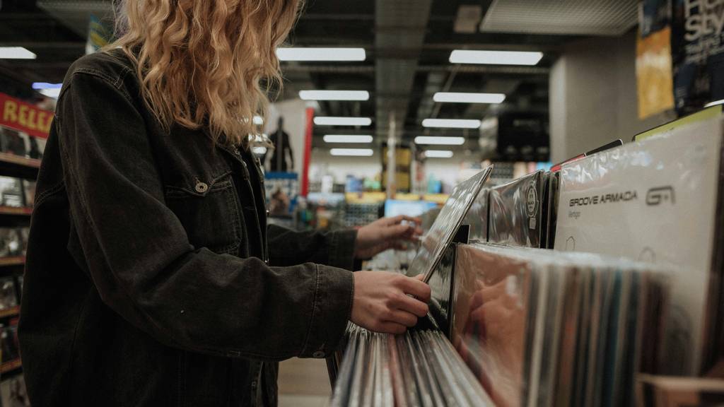Frau in Musikgeschäft kauft Vinyl