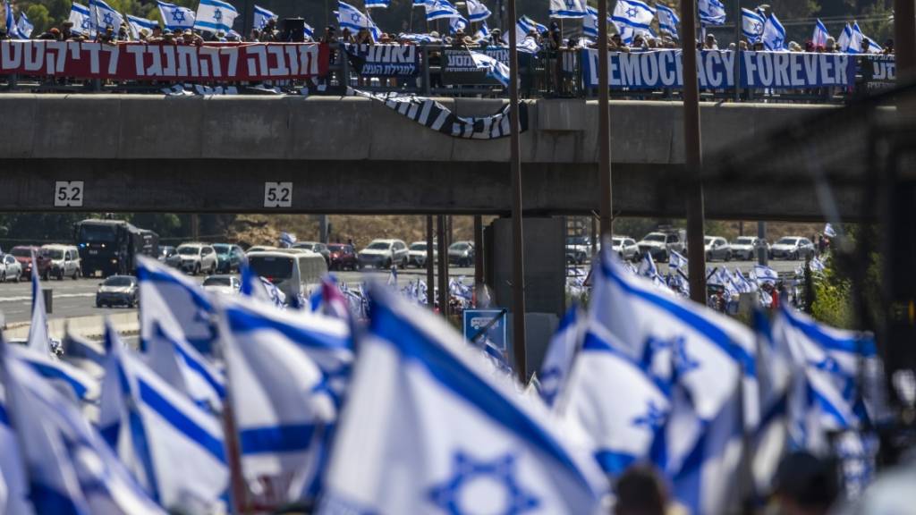 Tausende israelische Demonstranten marschieren entlang einer Autobahn, um gegen die geplante Justizreform der Regierung zu protestieren. Foto: Ilia Yefimovich/dpa