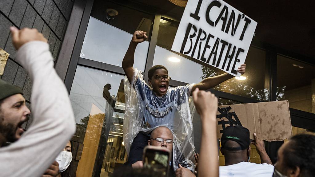 Demonstranten versammeln sich auf einem Polizeirevier und fordern mit einem Plakat mit der Aufschrift «I can't breathe» (dt. Ich kann nicht atmen) Gerechtigkeit für einen Mann afroamerikanischer Abstammung, der nach der Festnahme durch die Polizei verstarb. Der weiße Polizist kniete auf dem Hals des Mannes, welcher mehrmals darauf aufmerksam machte, dass er nicht atmen könne. Der Mann starb später im Krankenhaus. Foto: Richard Tsong-Taatarii/Star Tribune/AP/dpa