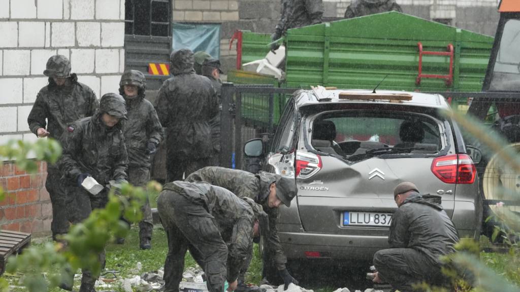 dpatopbilder - Einsatzkräfte der Territorialen Verteidigung räumen Trümmer vom zerstörten Dach eines Hauses auf, nachdem russische Drohnen den polnischen Luftraum verletzt haben. Foto: Czarek Sokolowski/AP/dpa