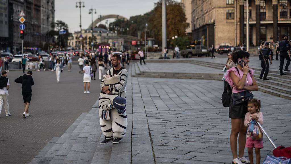 Ein ukrainischer Mann steht in einem Zebrakostüm auf dem Unabhängigkeitsplatz. Foto: Oliver Weiken/dpa