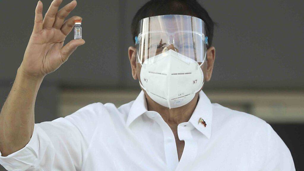 HANDOUT - Rodrigo Duterte, Präsident der Philippinen, hält  eine Ampulle mit dem Sinovac-Impfstoff aus China, nachdem der Impfstoff auf der Villamor Air Base eingetroffen ist. Foto: Toto Lozano/MALACANANG PRESIDENTIAL PHOTOGRAPHERS DIVISION/AP/dpa - ACHTUNG: Nur zur redaktionellen Verwendung im Zusammenhang mit der aktuellen Berichterstattung und nur mit vollständiger Nennung des vorstehenden Credits