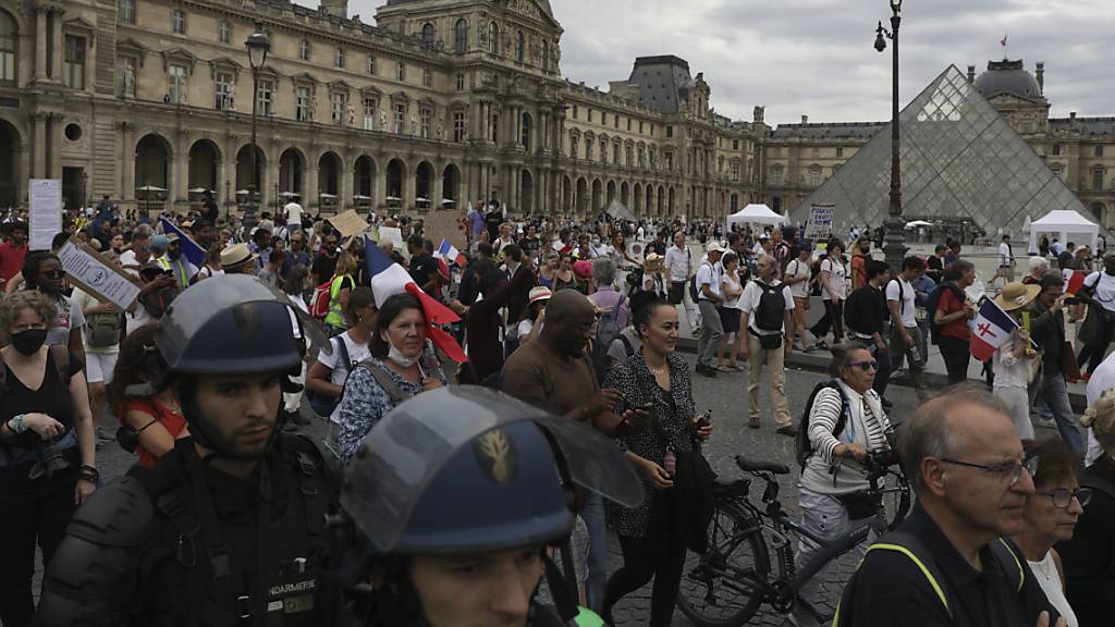 Demonstranten und Demonstrantinnen nehmen vor dem Louvre-Museum in Paris an einem Protest gegen den Gesundheitspass teil.