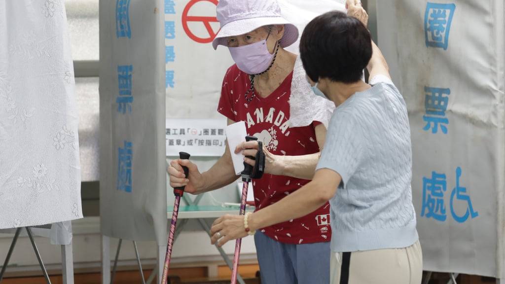 Eine Frau tritt aus einer Wahlkabine in einem Wahllokal in Taipeh, Taiwan. Foto: Chiang Ying-ying/AP/dpa