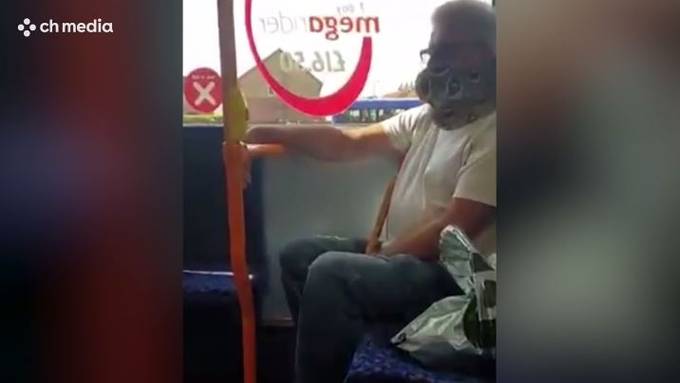 Mann benutzt lebende Schlange als Mundschutz im Bus