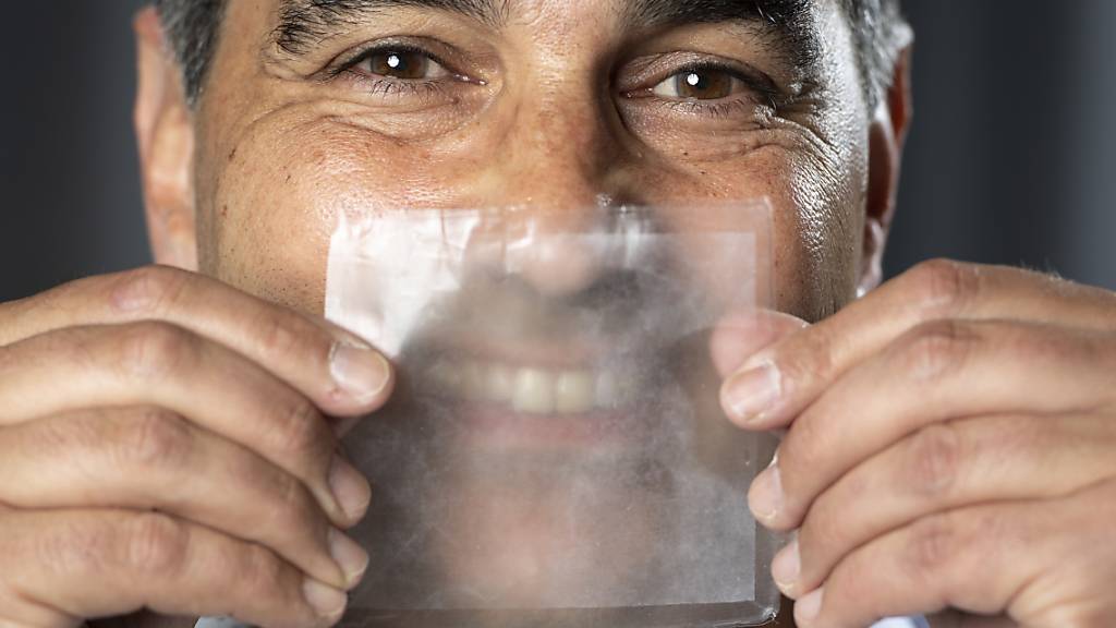 Hello Mask - So heisst die erste vollständig transparente Operationsmaske, die kurz vor der industriellen Herstellung steht. Projektchef Thierry Pelet zeigt mit einem Muster vor dem Gesicht, dass das Gegenüber sein Lächeln erkennen kann.