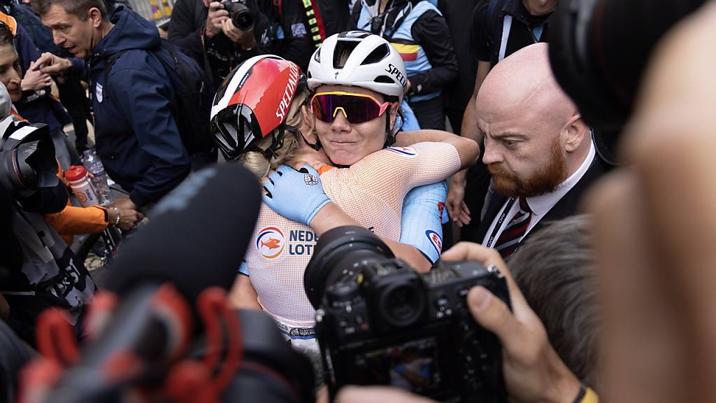 Strassen-Weltmeisterin Lotte Kopecky und die zweitplatzierte Demi Vollering liegen sich im Ziel in den Armen