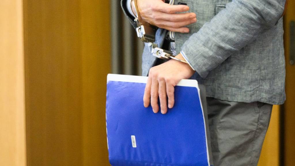 ARCHIV - Christian B. kommt in Handschellen und mit einem Aktenordner in der Hand in den Gerichtssaal im Landgericht Braunschweig. Foto: Julian Stratenschulte/dpa Pool/dpa