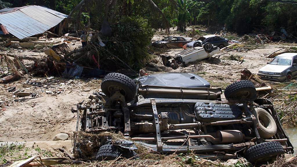 Beschädigte Autos und Trümmer nach den Überschwemmungen im Dorf Sg Lui. Foto: Dayana Nabila Shaipul Anuar/BERNAMA/dpa