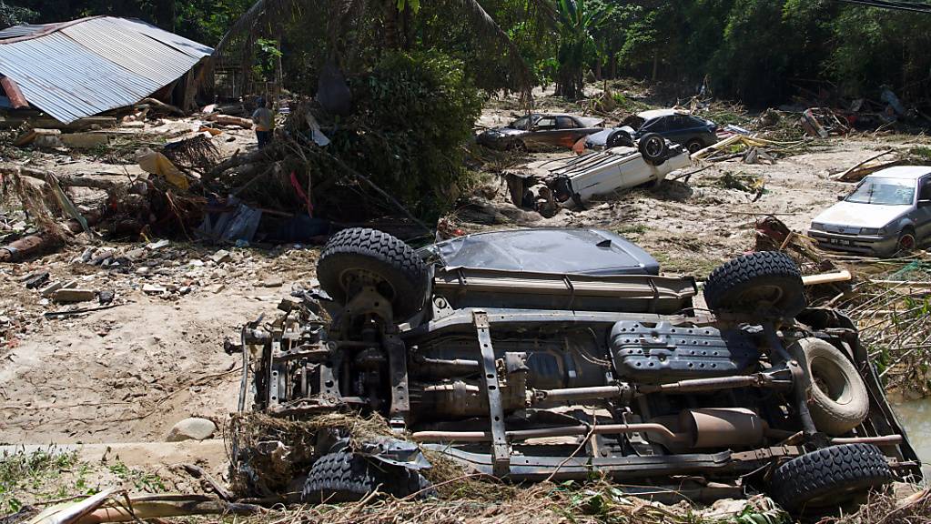 Beschädigte Autos und Trümmer nach den Überschwemmungen im Dorf Sg Lui. Foto: Dayana Nabila Shaipul Anuar/BERNAMA/dpa