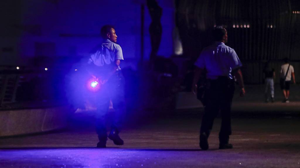 Polizeibeamte patrouillieren in der Star Avenue in Hongkong und raten der Öffentlichkeit, sich als Vorsichtsmaßnahme gegen den Taifun vom Hafen fernzuhalten. Foto: Daniel Ceng/AP/dpa