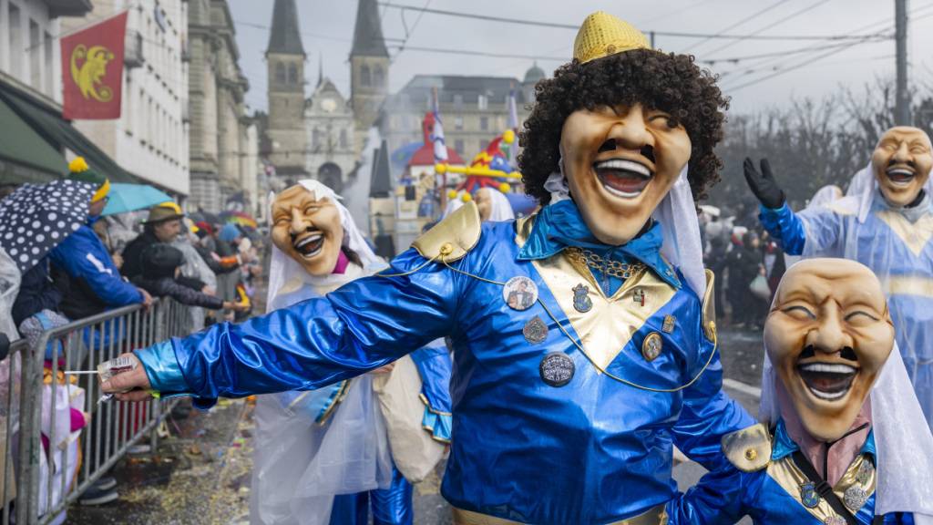 Eine Gruppe wilder Fasnachtskreaturen bei wechselhaftem Winterwetter am traditionellen Wey-Umzug in der Stadt Luzern.