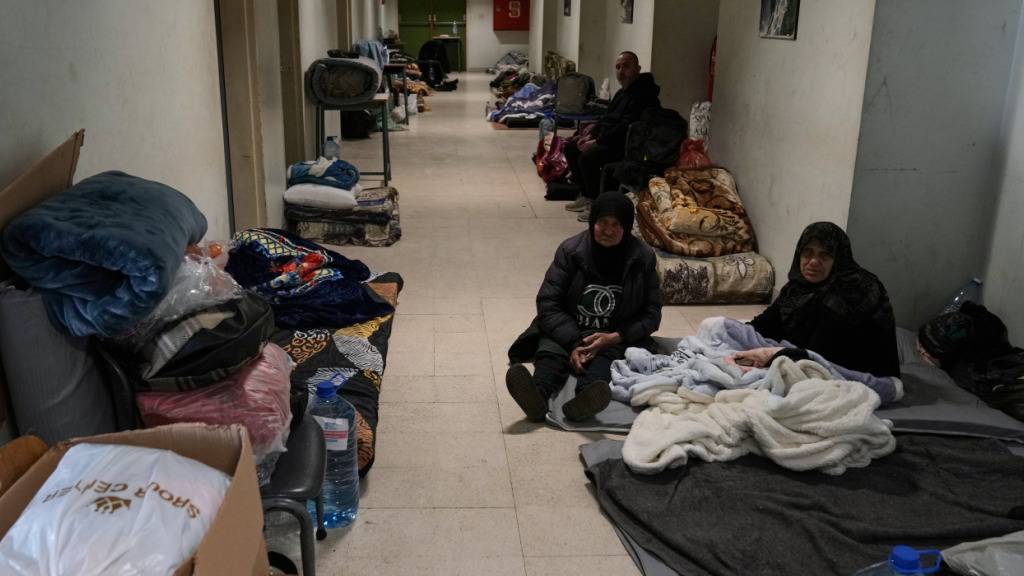 Vertriebene, die vor israelischen Luftangriffen im Südlibanon geflohen sind, lassen sich im technischen Institut Bir Hassan in Beirut nieder, das zu einer Notunterkunft umfunktioniert wurde. Foto: Bilal Hussein/AP/dpa