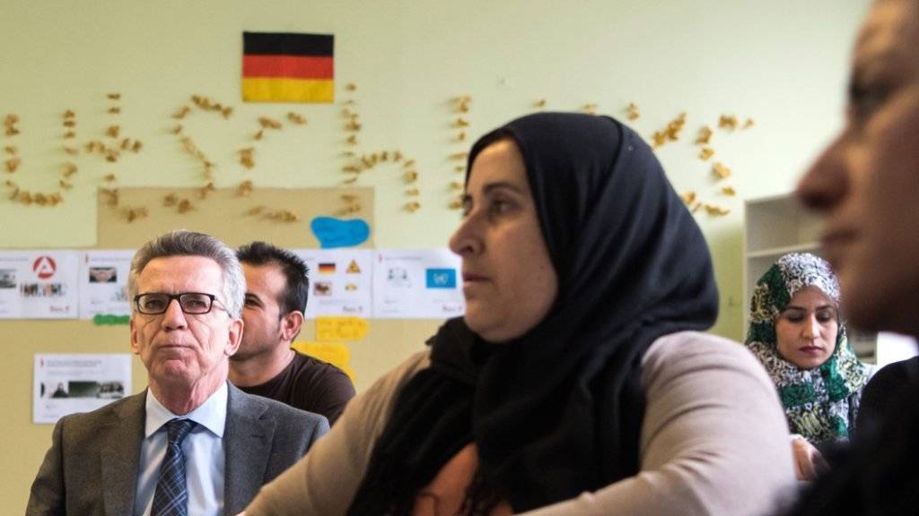 Deutschlands Innenminister Thomas de Maizière bei einer Orientierung mit muslimischen Asyl-Bewerberinnen