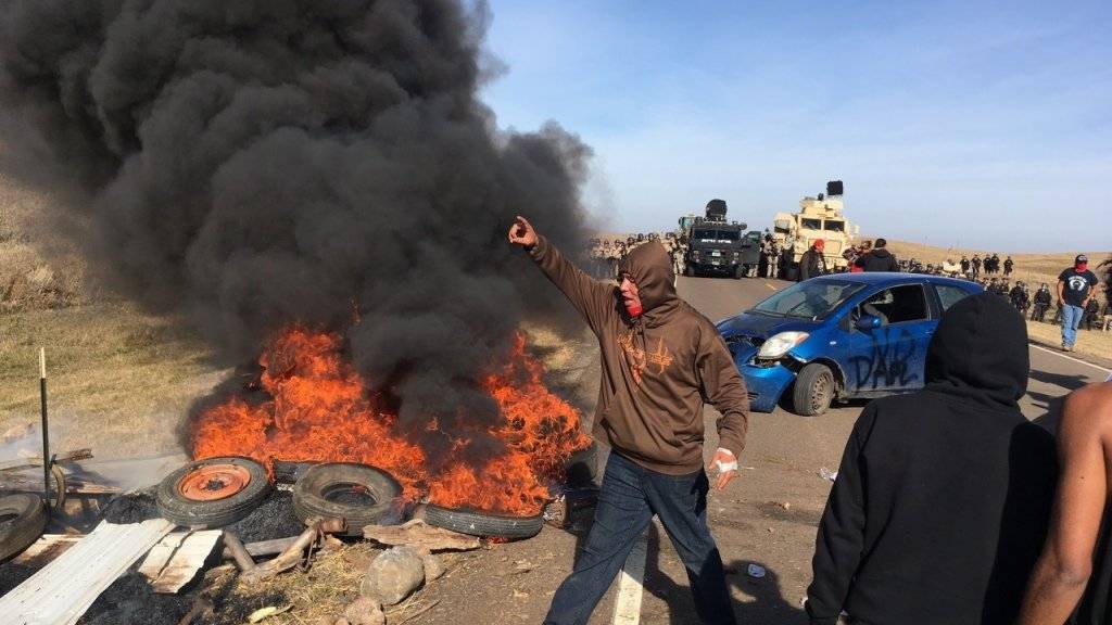 Bei Protesten gegen eine umstrittene Pipeline durch ein Stammesgebiet der Sioux-Indianer in North Dakota haben Demonstranten Pneus in Brand gesteckt.