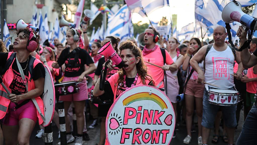 Israelische Demonstranten der «Rosa Front» halten Fahnen und rufen Slogans während eines Protestes gegen die Pläne der Regierung von Ministerpräsident Benjamin Netanjahu, das Justizsystem zu reformieren. Foto: Ilia Yefimovich/dpa