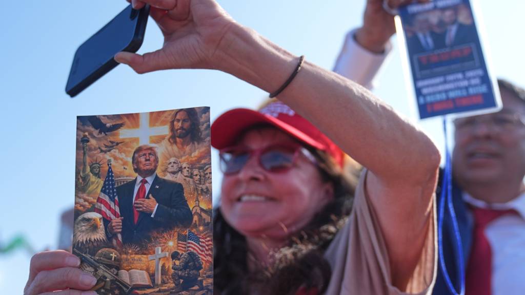 ARCHIV - Menschen hören US-Präsident Trump bei seiner Rede im Hafen von Corpus Christ, Texas, zu. Foto: Matt Rourke/AP/dpa
