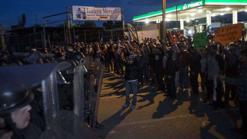 Demonstranten blockieren nahe von Tijuana eine Tankstelle und stehen Polizeikräften gegenüber