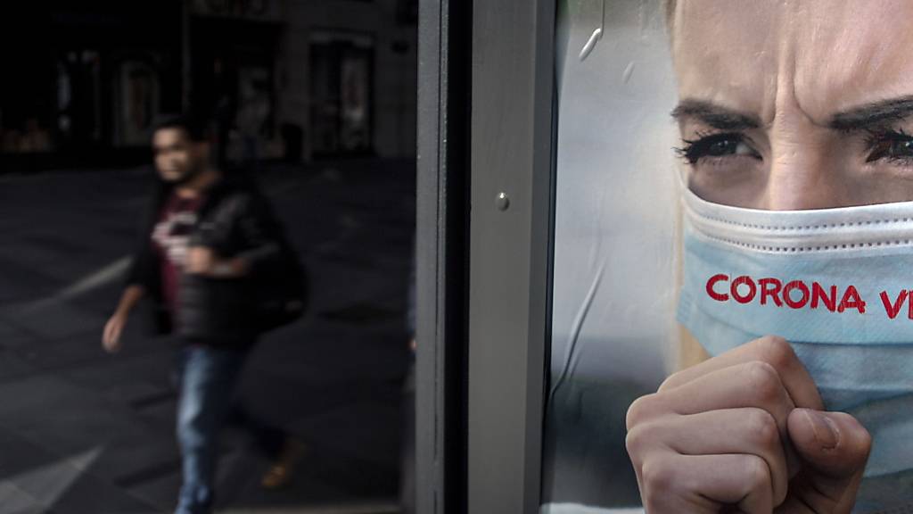 Ein Mann spaziert an einem Werbeplakat gegen das Coronavirus in Wien vorbei. (Archivbild)
