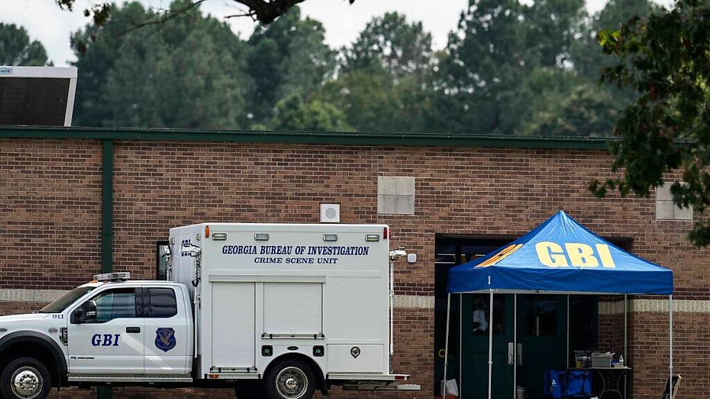 Mitarbeiter des Georgia Bureau of Investigation bewegen sich durch den Eingang der Apalachee High School, einen Tag nachdem ein 14-Jährige der Schule im Bundesstaat Georgia mindestens vier Menschen durch Schüsse getötet hat. Foto: Mike Stewart/AP/dpa