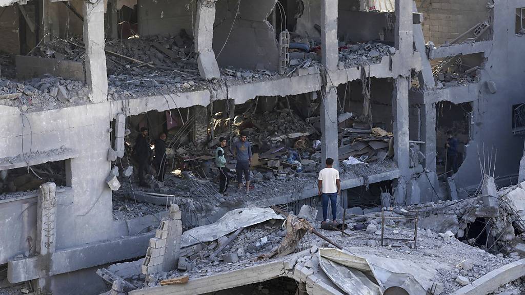 Palästinenser inspizieren die Trümmer eines zerstörten Gebäudes. Foto: Adel Hana/AP/dpa