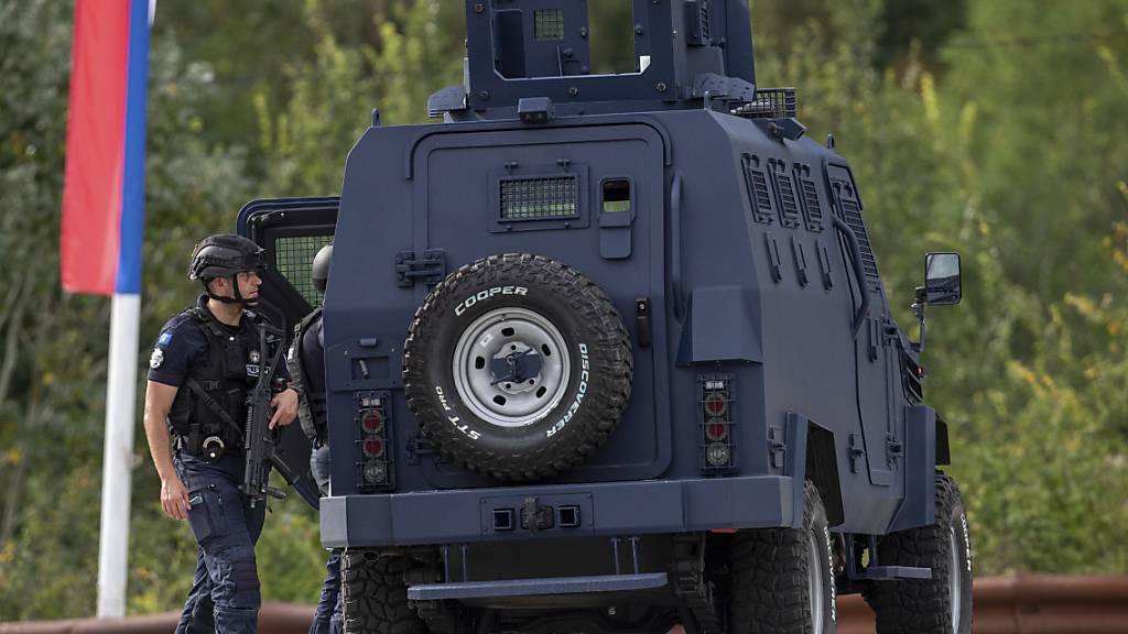 Polizisten sichern nach einem Angriff am 24. September eine Kreuzung vor dem Ort Banjska im Nordkosovo. Nun kam es in der serbischen Hauptstadt Belgrad zu einer Festnahme. (Archivbild) Foto: Visar Kryeziu/AP/dpa