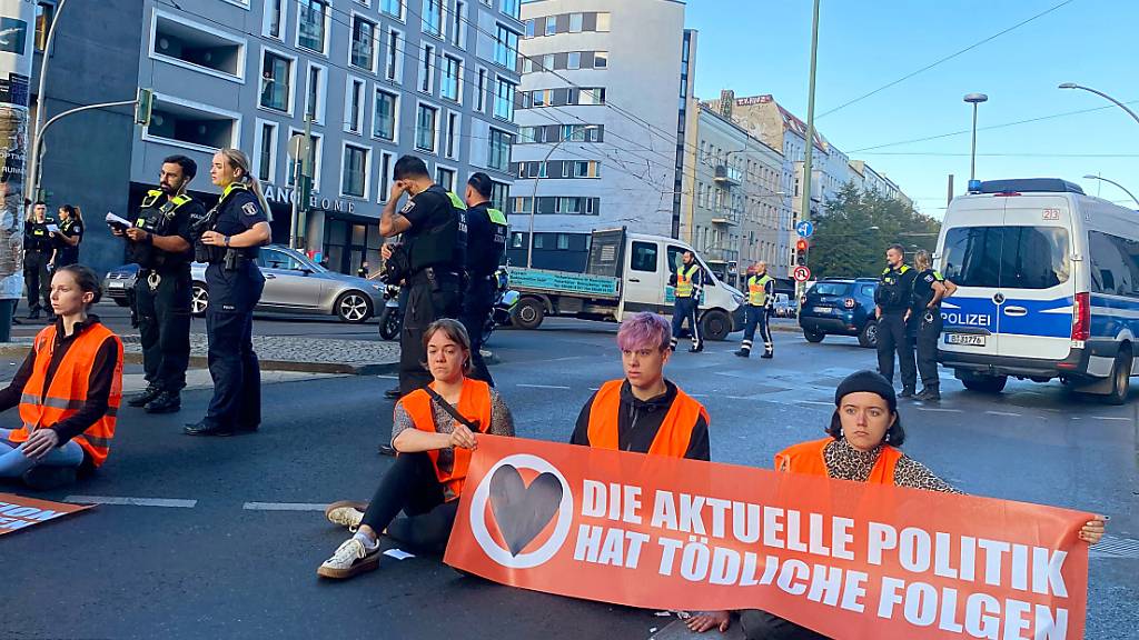 Aktivisten und Aktivistinnen der Klimaschutzgruppe Letzte Generation bei der Blockade einer Straßenkreuzung in Berlin. Während der laufenden Proteste der Gruppe Letzte Generation hat ein Gericht in Berlin gegen eine Klimademonstrantin eine harte Strafe ausgesprochen. Eine 41-Jährige aus Köln soll acht Monate ins Gefängnis. Foto: Sascha Meyer/dpa